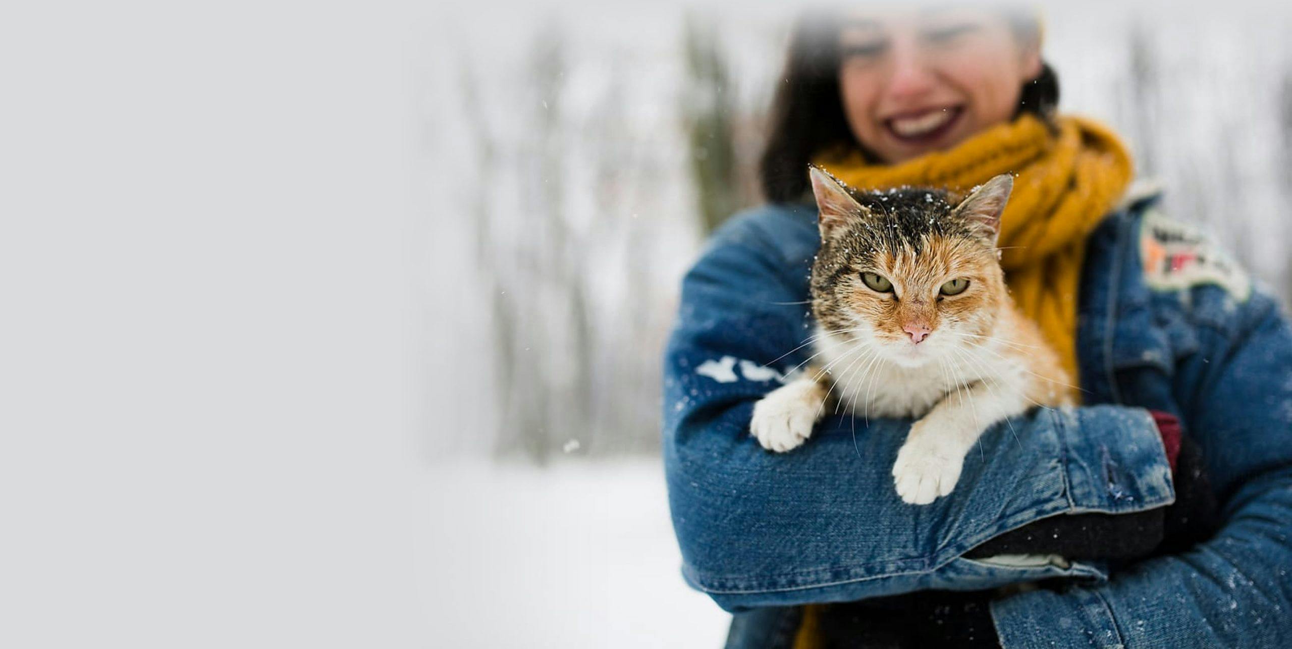 Woman with her pet cat in the snow